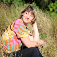 Portrait of Alicia Yusuf sitting in meadow